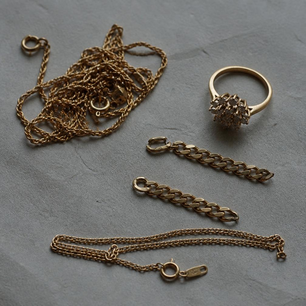 Tangled old gold chains and a dated cluster ring before reworking
